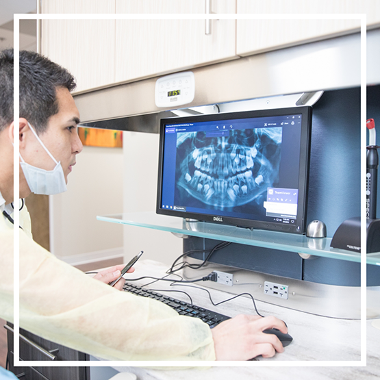 Dentist looking at x rays of a patient's teeth