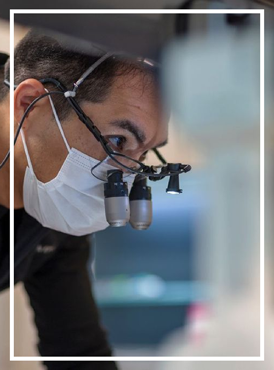 Doctor Kham wearing dental binoculars while treating a patient