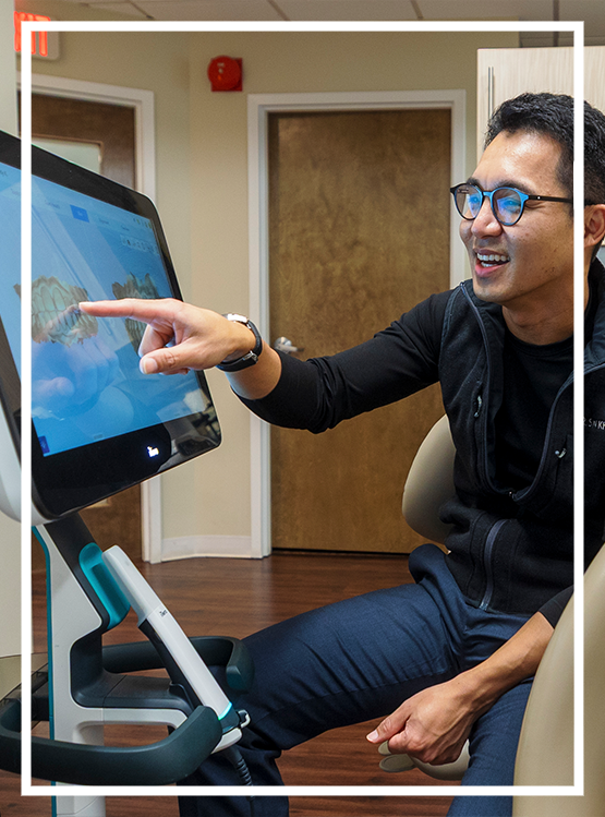 Man looking at his smile in a mirror after cosmetic dentistry in Washington, DC