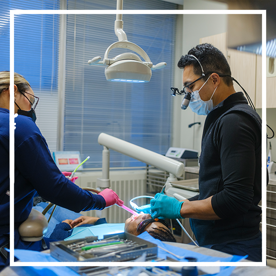 Woman holding her cheek in pain while talking to her emergency dentist