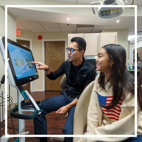 Doctor Kham showing a patient scans of their teeth