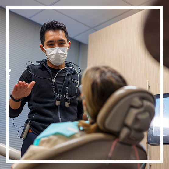 Doctor Kham talking to a woman in the dental chair