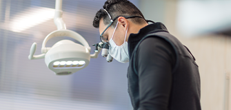 Man with gray hair and glasses smiling outdoors
