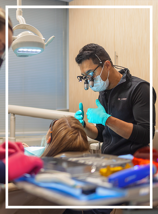 Older woman smiling with her hands folded under her chin